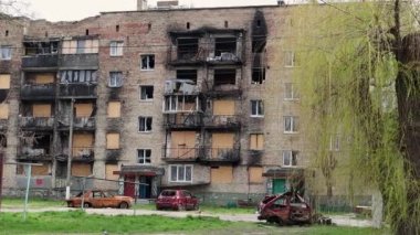 Şehirdeki bombalı saldırının sonuçları. Roket evi havaya uçurdu. Bombalanmış bir apartman ve hava saldırısından sonra yanmış arabalar. Mermilerden duvarlarda delikler var. Mülkiyet kalıntıları