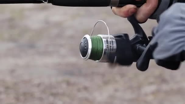 The bite alarm hangs on a fishing rod against the background of water. Fishing  rod while fishing on the lake, river. Fishing tackle. Carp rod on a stand  with a bite alarm