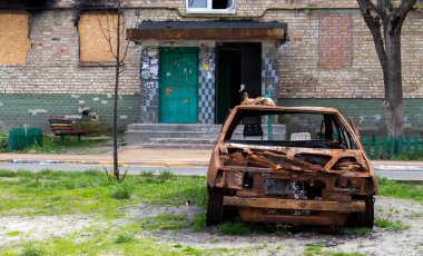 Şehirdeki bombalı saldırının sonuçları. Roket evi havaya uçurdu. Bombalanmış bir apartman ve hava saldırısından sonra yanmış arabalar. Mermilerden duvarlarda delikler var. Mülkiyet kalıntıları