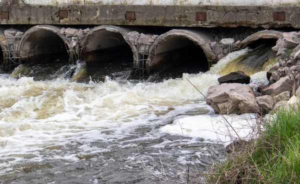 stock image A concrete pipe that carries smelly, polluted sewage into the river through pipes. Pollution of the environment and water bodies. Ecological catastrophy. Hazardous waste water