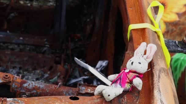 火災後の遺跡で子供のおもちゃのクローズアップ 爆撃の結果焼失した車の中で柔らかいおもちゃ 破滅した子供時代 戦争の概念 ウクライナだ 危険な交通事故 — ストック動画