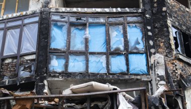 Kırık camlı evin penceresi. Seçici odaklanma. Apartmandaki pencereler patlamadan ve mermi parçalarından zarar görmüş. Yıkım, savaşın sonuçları.