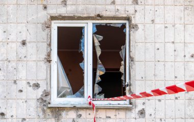 Kırık camlı evin penceresi. Seçici odaklanma. Apartmandaki pencereler patlamadan ve mermi parçalarından zarar görmüş. Yıkım, savaşın sonuçları.