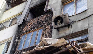 Rus işgali Ukrayna 'da. Bombardımandan sonra şehirde yıkılan bir bina. Felaket, yıkım. Çok katlı bir binada yangın çıktı. Dışarıda yanmış siyah bir balkon ve pencereler var.