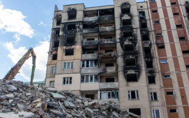 Binanın eski sökülme sürecinin yıkılması süreci. Kazı makinesi evi dağıtıyor. Harap olmuş konutların yıkılması. İnşaat kazıcısı tadilat için bir evi yıkıyor