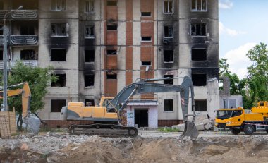 Binanın eski sökülme sürecinin yıkılması süreci. Kazı makinesi evi dağıtıyor. Harap olmuş konutların yıkılması. İnşaat kazıcısı tadilat için bir evi yıkıyor