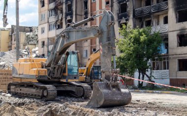 Çok katlı apartmanların yıkımı üzerine inşaat çalışması. Kırmızı ve beyaz uyarı bandından yapılmış. Harap olmuş konutların yıkılması. Büyük bir yangından sonra konut binası. Şehir yenilenmesi