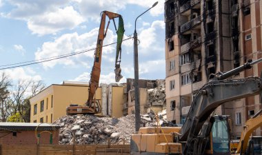 Binanın eski sökülme sürecinin yıkılması süreci. Kazı makinesi evi dağıtıyor. Harap olmuş konutların yıkılması. İnşaat kazıcısı tadilat için bir evi yıkıyor