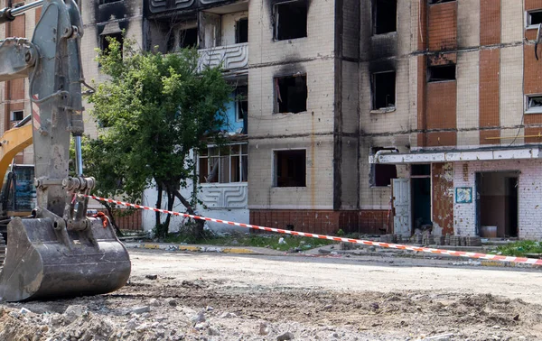 stock image Construction work on the demolition of multi-storey apartments. Fence made of red and white warning tape. Demolition of dilapidated housing. Residential building after a major fire. City renewal