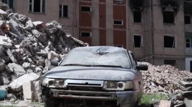 Broken civilian car in the courtyard of the house. War between Russia and Ukraine. The consequences of the occupation of a peaceful city