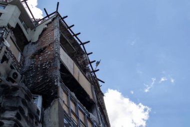 Güçlü bir yangından sonra yüksek katlı bir bina. Daireler ve balkonlar roketle vurulduktan sonra yangınla yıkıldı. Yangından sonra terk edilmiş bir gökdelenin cephesi.