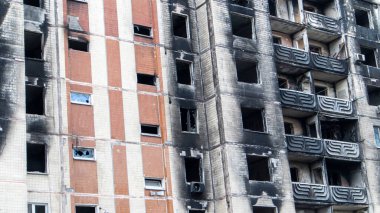Güçlü bir yangından sonra yüksek katlı bir bina. Daireler ve balkonlar roketle vurulduktan sonra yangınla yıkıldı. Yangından sonra terk edilmiş bir gökdelenin cephesi.