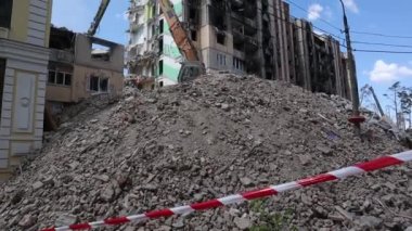 Çok katlı apartmanların yıkımı üzerine inşaat çalışması. Kırmızı ve beyaz uyarı bandından yapılmış. Harap olmuş konutların yıkılması. Büyük bir yangından sonra konut binası. Şehir yenilenmesi