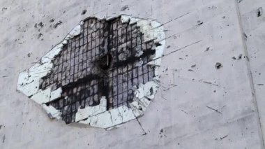 Çok katlı bir binaya isabet eden topçu mermisi izleri. Binanın bir kısmı şok dalgası ve şarapnel yüzünden tahrip oldu. Evde bombardıman