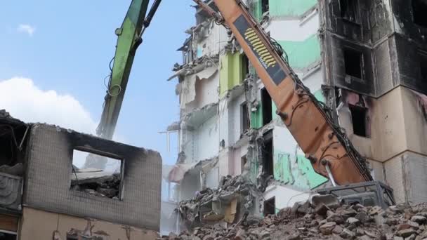 在一场大火之后 一座多层住宅的立面被废弃了 一台装有液压破碎机的建筑挖掘机拆毁房屋进行修理 一幢住宅楼的倒塌 — 图库视频影像