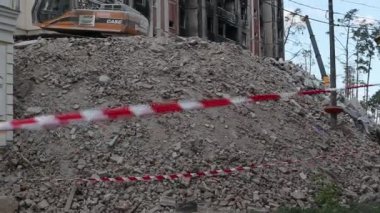 Çok katlı apartmanların yıkımı üzerine inşaat çalışması. Kırmızı ve beyaz uyarı bandından yapılmış. Büyük bir yangından sonra konut binası. Şehir yenilenmesi. Ukrayna, Irpin - 12 Mayıs 2023