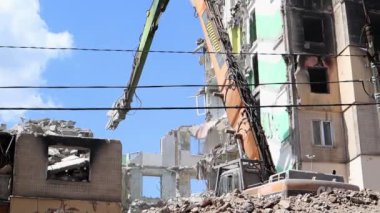 Eski binayı sökme işlemi için. Kazı makinesi evi dağıtıyor. Harap olmuş konutların yıkılması. İnşaat kazıcısı evi yıkıyor. Ukrayna, Irpin - 12 Mayıs 2023
