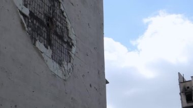Çok katlı bir binaya isabet eden topçu mermisi izleri. Binanın bir kısmı şok dalgası ve şarapnel yüzünden tahrip oldu. Evde bombardıman