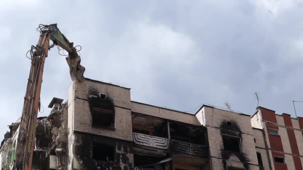 在一场大火之后 一座多层住宅的立面被废弃了 一台装有液压破碎机的建筑挖掘机拆毁房屋进行修理 一幢住宅楼的倒塌 — 图库视频影像