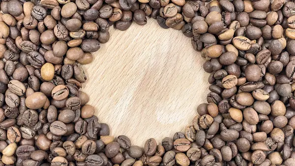 Roasted coffee beans can be used as a background. Top view of aromatic brown coffee beans scattered on the surface. Copy space, space for text or logo