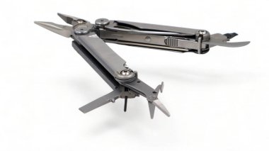 Beyaz arka planda pense, dosya, bıçak, tornavida, makas, şişe açacağı ve testere ile modern çelik çoklu alet açıldı. Küçük ve taşınabilir ürün. Çakı. EDC kavramı