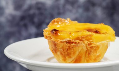 Bir portekizli Pastel de Nata quiche tabağı. Pastel de Belem, yanmış kapağı ve çıtır börek hamuru olan manastır ve kült bir pastadır. Tatlı, kremalı.