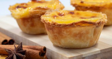 Pastel de nata turtaları ya da Portekiz yumurtalı tart ve tarçınlı çubuklar. Pastel de Belem çıtır börek hamurlu ve kremalı küçük bir turta.