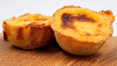 Pastel de nata turtaları ya da kahverengi arka planda Portekiz yumurtalı turtası. Pastel de Belem çıtır börek hamurlu ve kremalı küçük bir turta. Tatlı tatlı