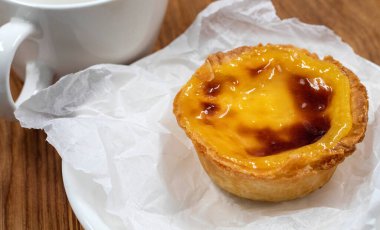Beyaz tabakta bir Pastel de nata veya Portekiz yumurtalı turtası. Pastel de Belm çıtır börek hamurlu ve kremalı küçük bir turta.