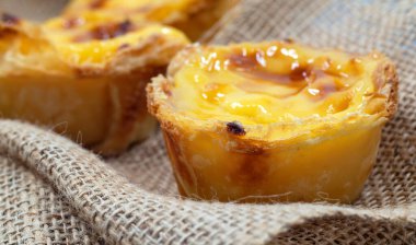 Bir sürü taze pişmiş tatlı Pastel de nata veya Portekiz yumurtalı tartı. Pastel de Belm çıtır börek hamurlu ve kremalı küçük bir turta. Küçük bir tatlı, bir kek.