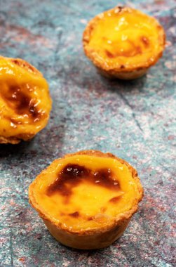Bir sürü taze pişmiş tatlı Pastel de nata veya Portekiz yumurtalı tartı. Pastel de Belm çıtır börek hamurlu ve kremalı küçük bir turta. Küçük bir tatlı, bir kek.