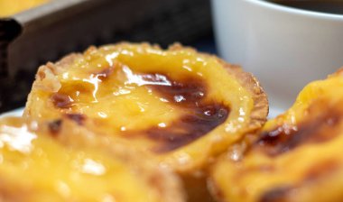 Pastel de nata ya da Portekiz yumurtalı tart ve bir fincan sade kahve. Pastel de Belm çıtır börek hamurlu ve kremalı küçük bir turta.