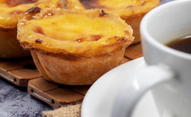 Pastel de nata ya da Portekiz yumurtalı tart ve bir fincan sade kahve. Pastel de Belm çıtır börek hamurlu ve kremalı küçük bir turta.