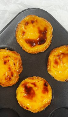 Fırında pişmiş taze Pastel de nata ya da Portekiz yumurtalı tart tatlısı var. Pastel de Belme çıtır börek hamurlu ve kremalı küçük bir turta. Küçük kek.
