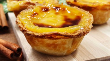 Pastel de nata ya da Portekiz yumurtalı tart ve tarçınlı çubuklar. Pastel de Belm çıtır börek hamurlu ve kremalı küçük bir turta.