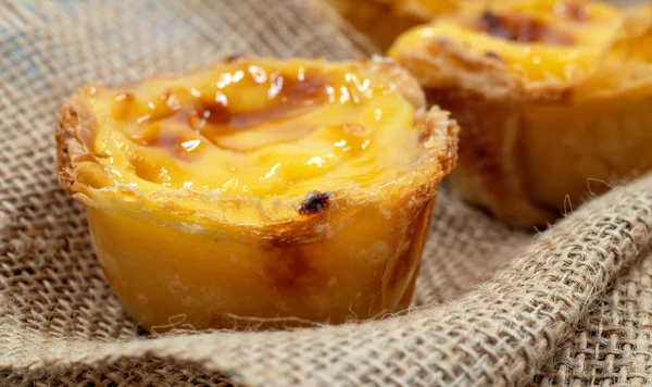Bir sürü taze pişmiş tatlı Pastel de nata veya Portekiz yumurtalı tartı. Pastel de Belm çıtır börek hamurlu ve kremalı küçük bir turta. Küçük bir tatlı, bir kek.