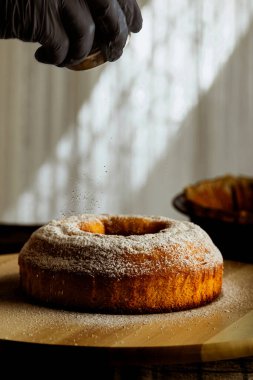 Adam el kreması şekeri ev yapımı kekin üzerinde ahşap tabakta.