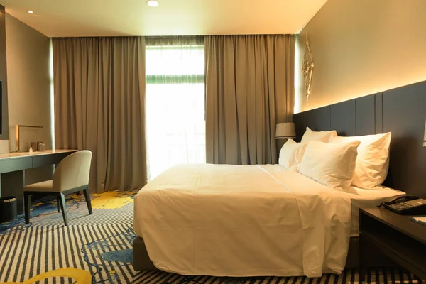 White bed in a room with warm light