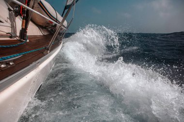 Dalgalar arasında yelkenliyle yelken açmak dalgalı bir denizde, bir sürü sıçrama.