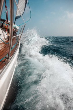 Dalgalar arasında yelkenliyle yelken açmak dalgalı bir denizde, bir sürü sıçrama.