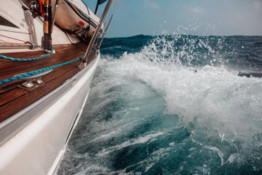 Dalgalar arasında yelkenliyle yelken açmak dalgalı bir denizde, bir sürü sıçrama.