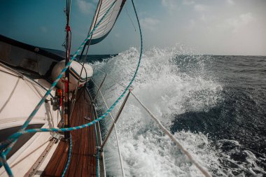 Dalgalar arasında yelkenliyle yelken açmak dalgalı bir denizde, bir sürü sıçrama.