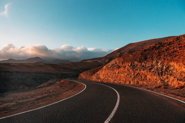 Lanzarote adasının volkanik manzaraları. Uzağa uzanan bir yol. Panoramik kuş bakışı mağaralar, uçurumlar, dağlar. Kanarya Adaları 'nda popüler bir turizm merkezi.