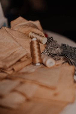 Eski püskü bir masaüstünde eski bej dikiş iplikleri antika kumaş üzerinde. Tekstil ya da kaliteli kumaş üretimi. Sanayi kumaşları, dantel. Yüksek kalite fotoğraf
