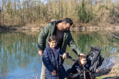 Babamın puset ve iki çocuğuyla baharda Aare nehri boyunca yürüdüğü yakın plan..