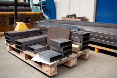 metal tubes on yellow pallet lifter at the factory