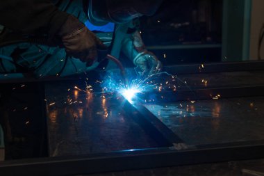welder uses torch in factory