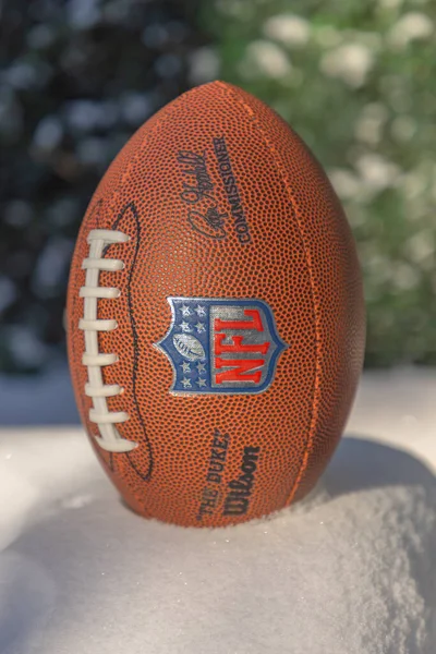 米国ペンシルベニア州ピッツバーグ 2022年11月8日 全米サッカーリーグ Nfl のロゴ入りのアメリカのサッカーボールが冬の間雪の上に — ストック写真