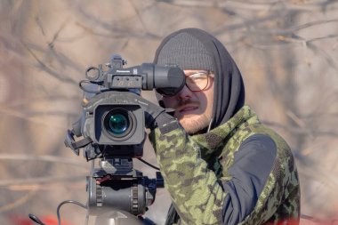 Nov 11, 2022. Calgary, Alberta, Canada. Front view of a Panasonic P2HD camera man filming out in the cold weather. clipart