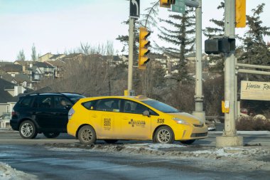 Calgary, Alberta, Kanada. 31 Aralık 2022. Kış boyunca araba kullanan sarı bir taksi..